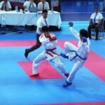 Dos karatecas intercambian patadas durante una competencia de la Gimnasiada Nacional 2026 en la Ciudad Deportiva de Alto Rendimiento.
